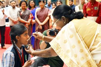 The Hon’ble President feeds a child, symbolising the nation’s commitment to nurturing the future.