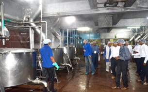 Dignitaries keenly observing the cauldrons bubble away as they tour the facility