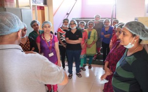Volunteers listening to Anilkumar T.B., AGM – Program Management, as he guided them through the kitchen operation
