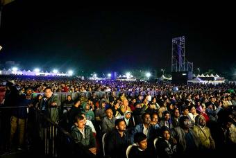The crowd braves the cold night and is mesmerised as the singers perform on the stage.
